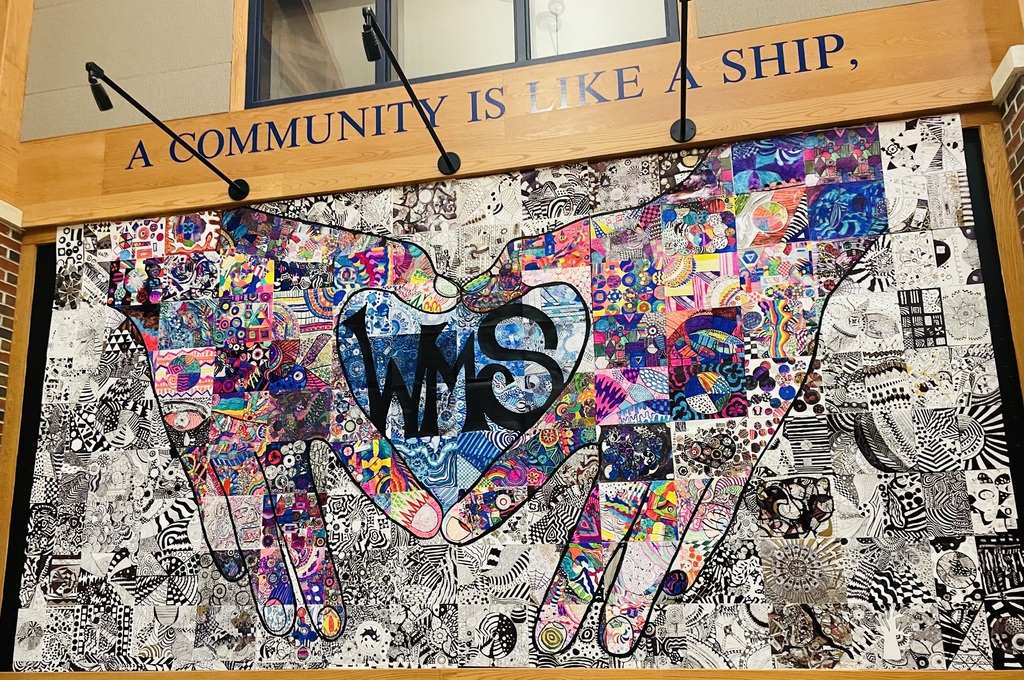 A mural of two hands holding a WMS heart icon.