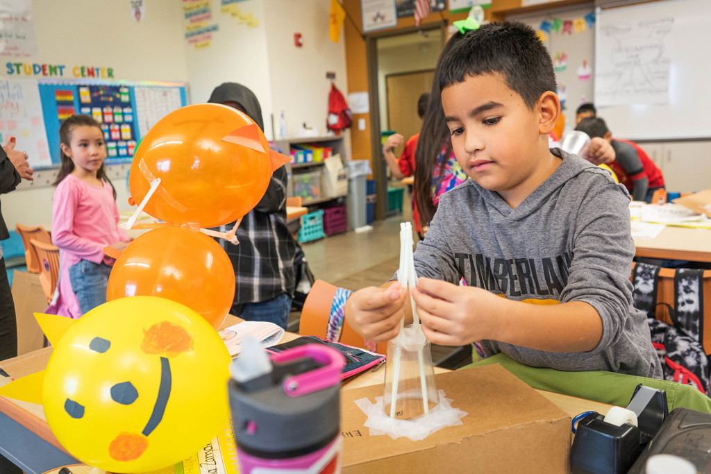 Child creating a balloon design