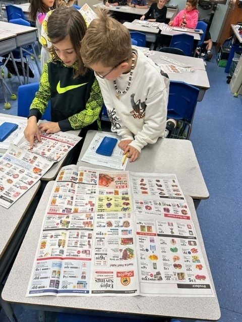 Two boys picking items from grocery store circular
