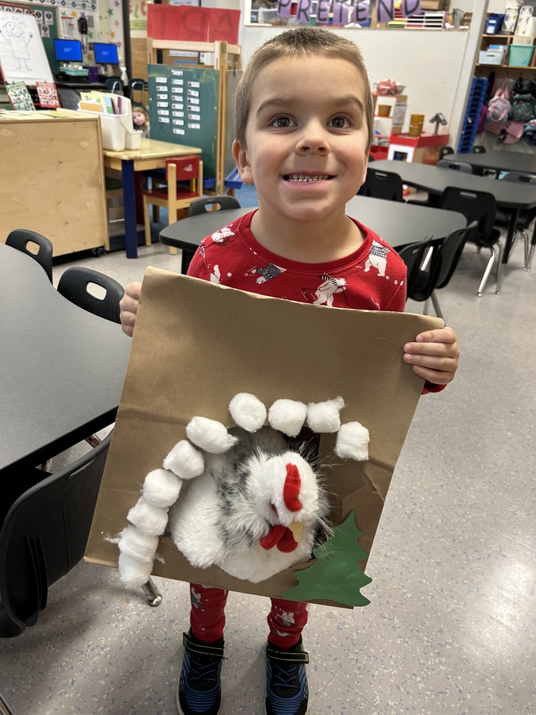 students holding paper bag made to look like a cave for a stuffed animal