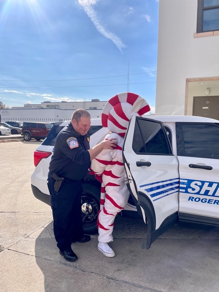 zebra masscot and elf getting into police car