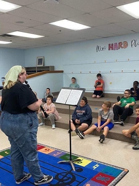 OSU student playing clarinet for kids