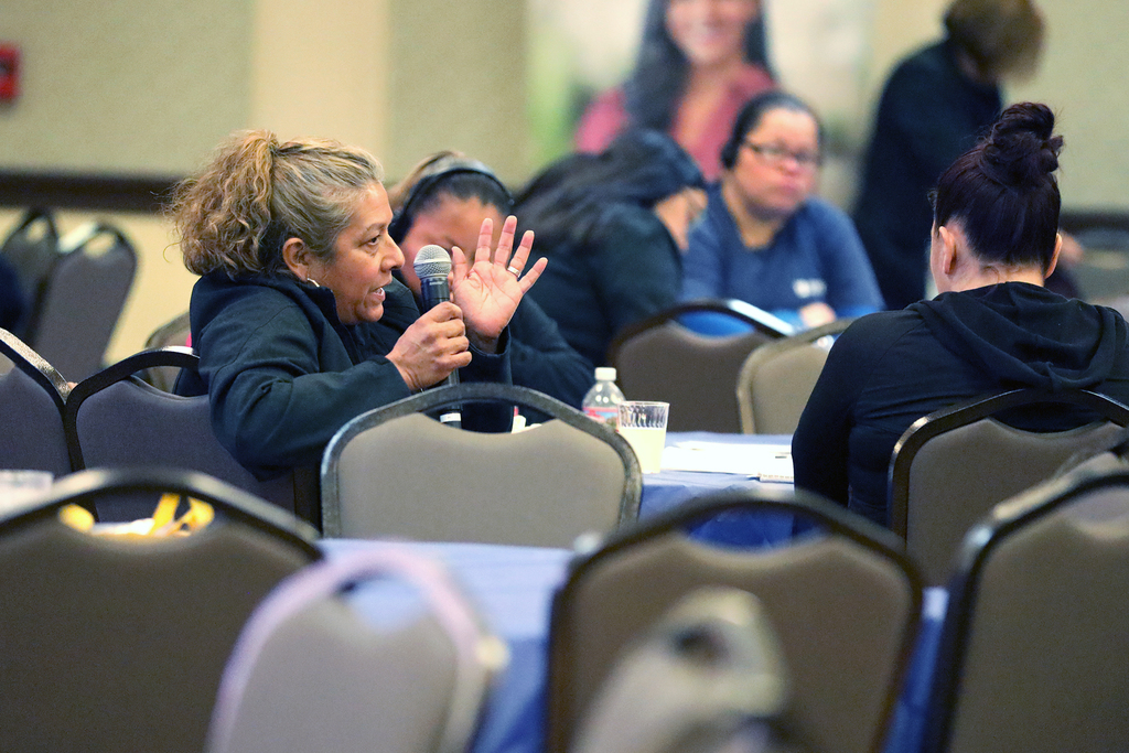 An audience member speaks into a handheld microphone at the town hall meeting