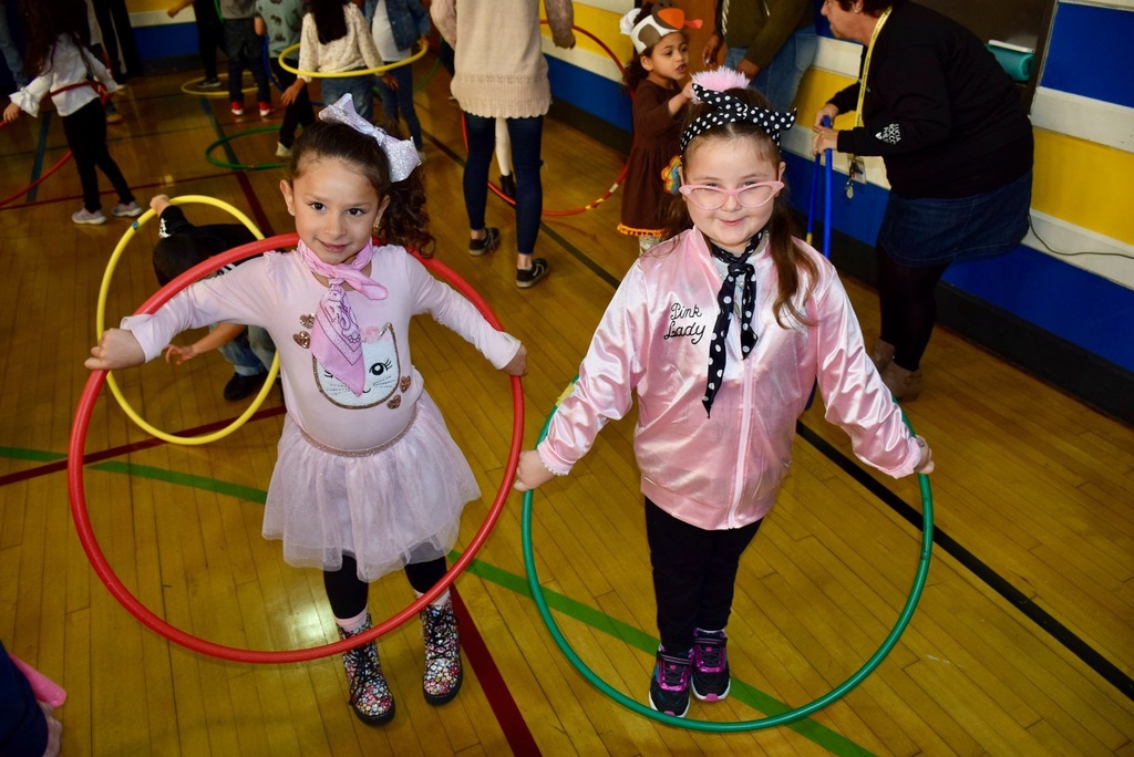 two female students posing with hula hoops