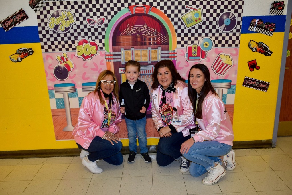 one male student posing with teachers / parents