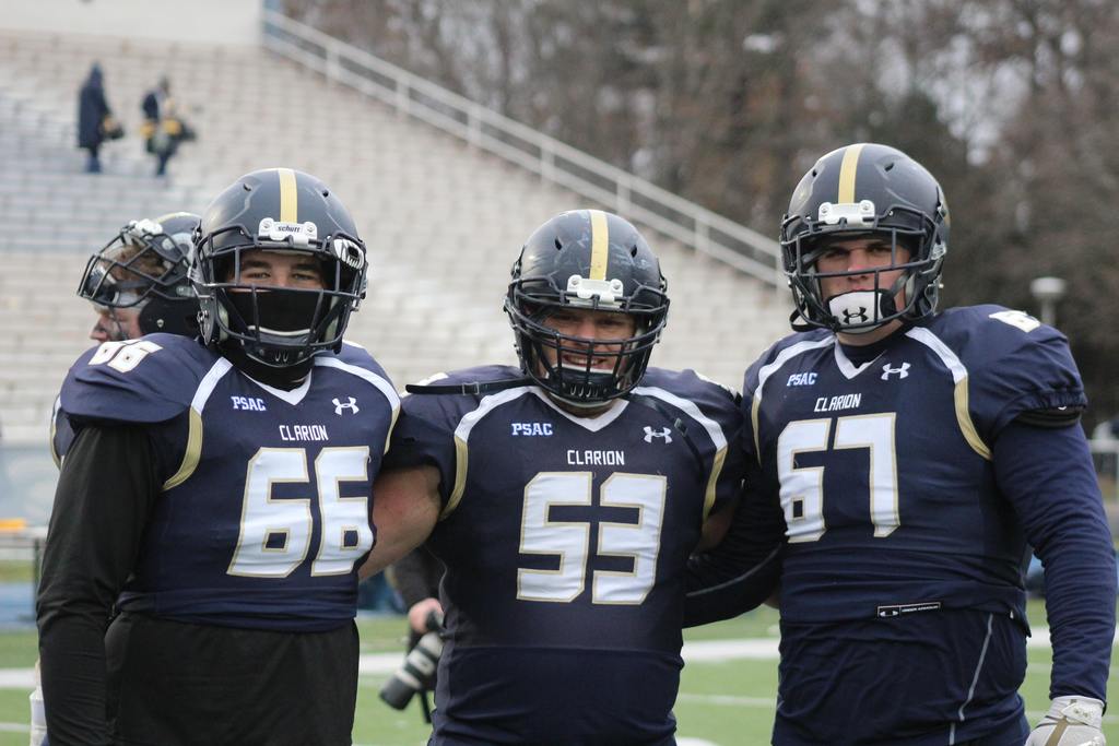 three football players in full uniform on field 