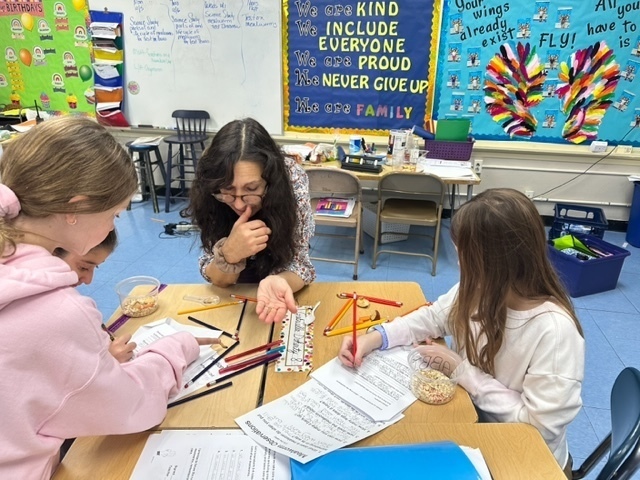 Mrs. Wade observing mealworms with three students