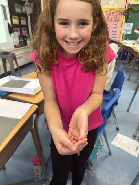 fourth grade girl holding mealworm