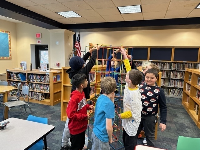 a group of boys building a tall tower during recess