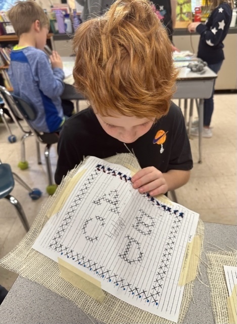 second grade boy stitching
