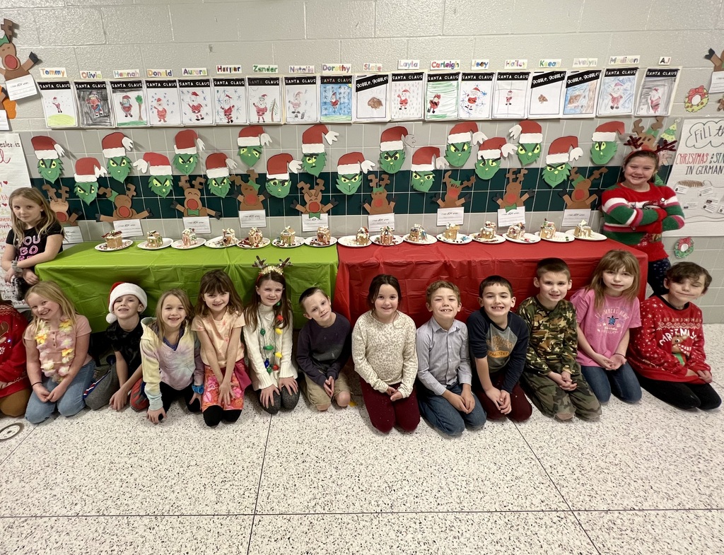 students lined up by table with gingerbread houses