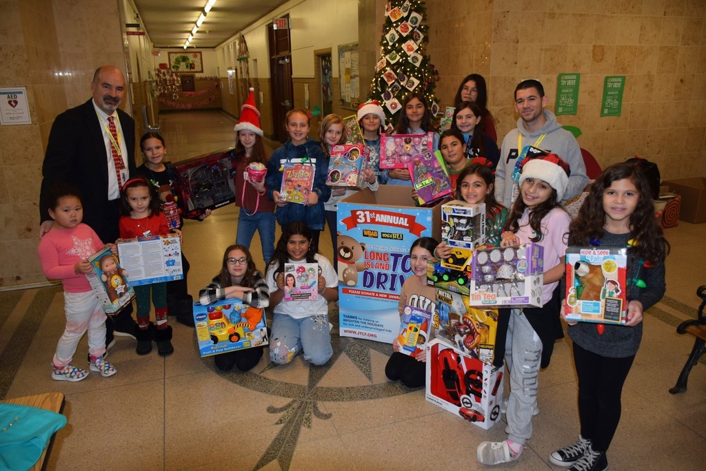 Building Principal and AP pose with students showcasing fundraising efforts