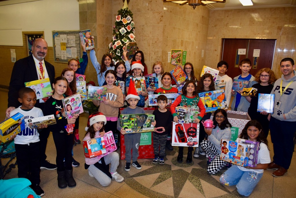 Building Principal and AP pose with students showcasing fundraising efforts