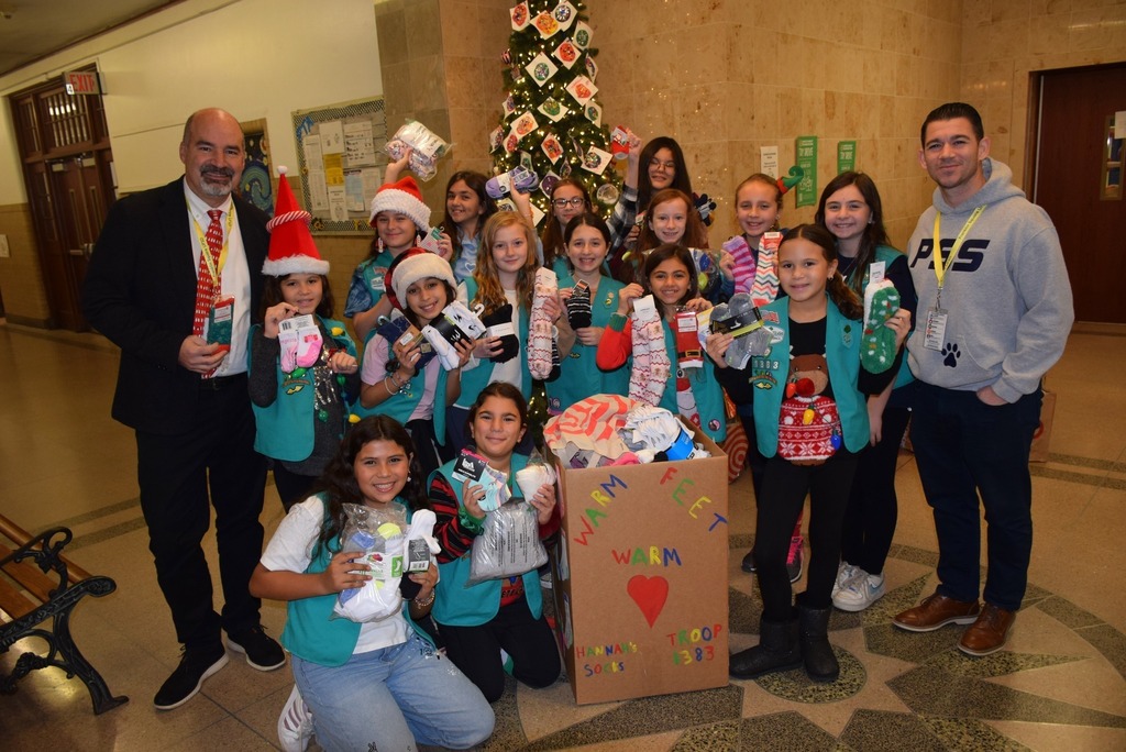 Building Principal and AP pose with students showcasing fundraising efforts
