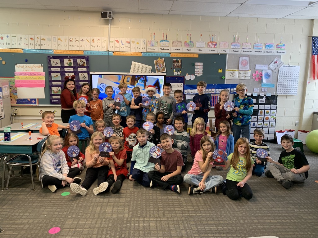 students holding snow globe project they made