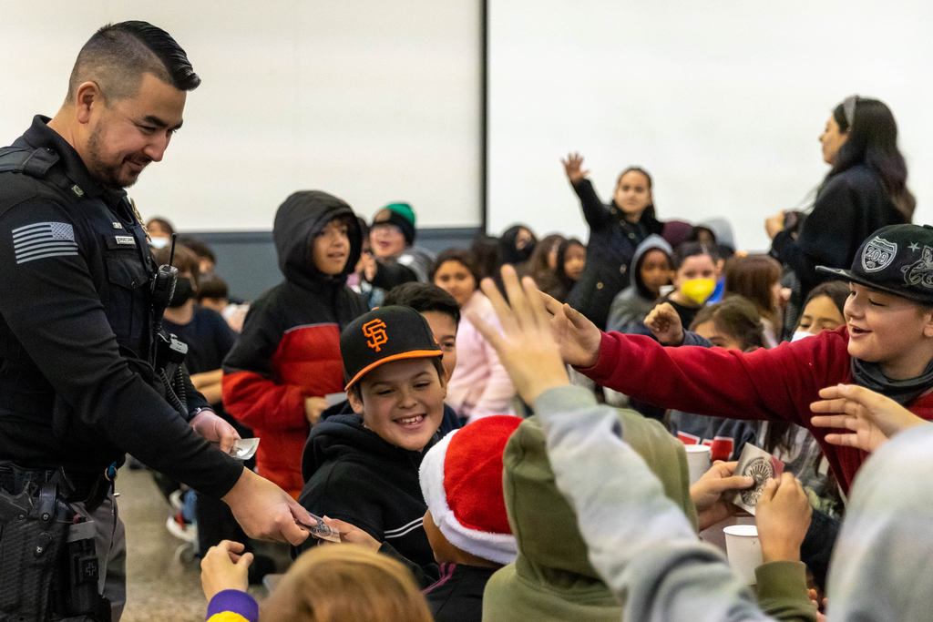 Ceres Police officer hands out stickers to students