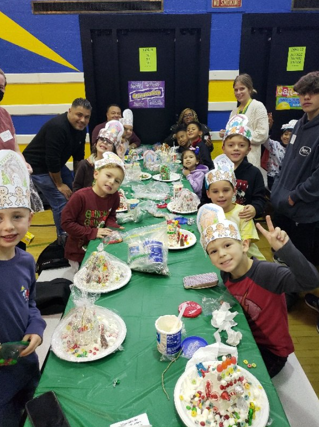 students and families show off their gingerbread houses