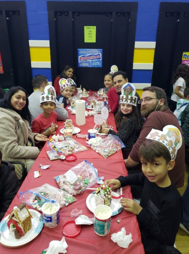students and families show off their gingerbread houses
