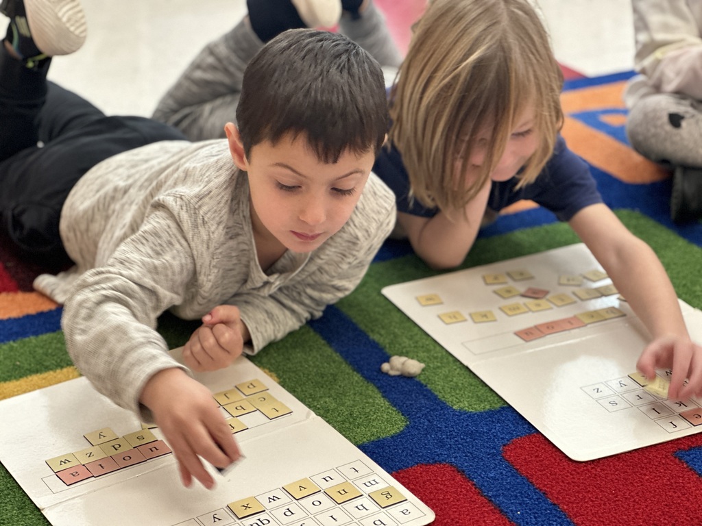 Students manipulating the magnetic letter board