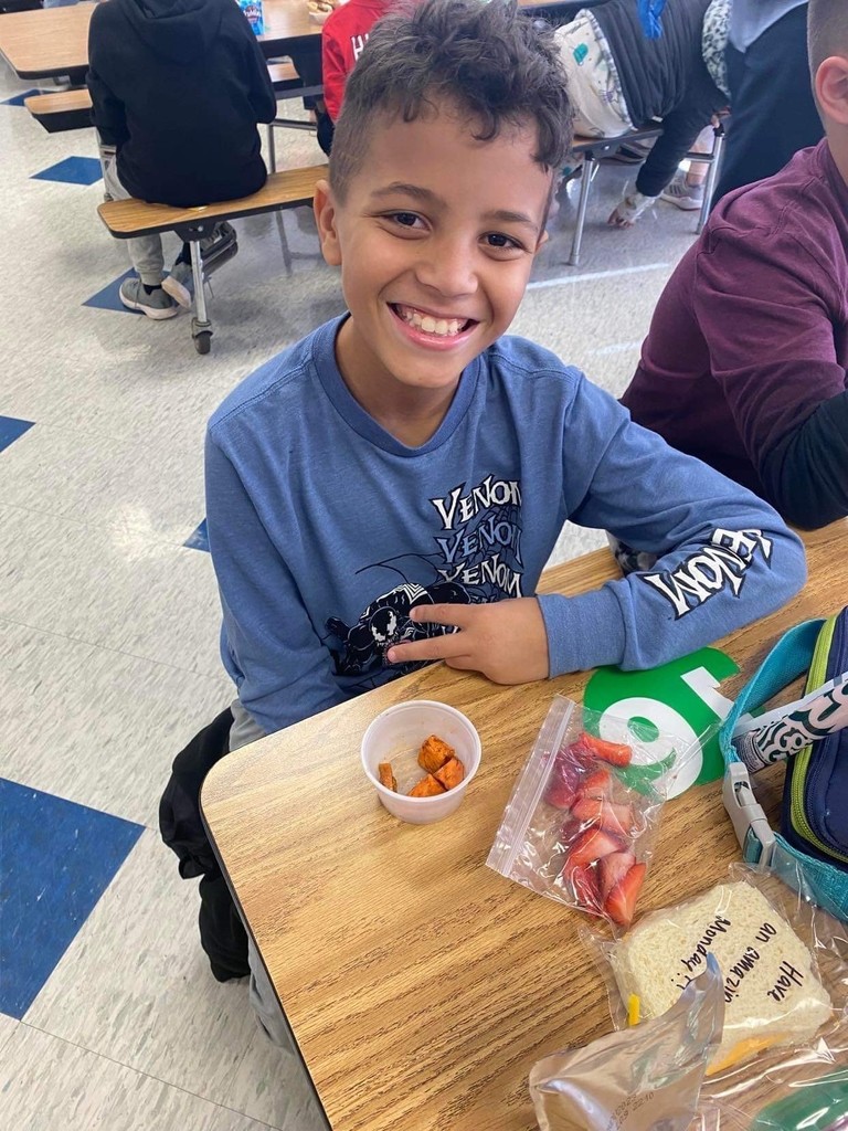 student smiling, with cup of sweet potatoes