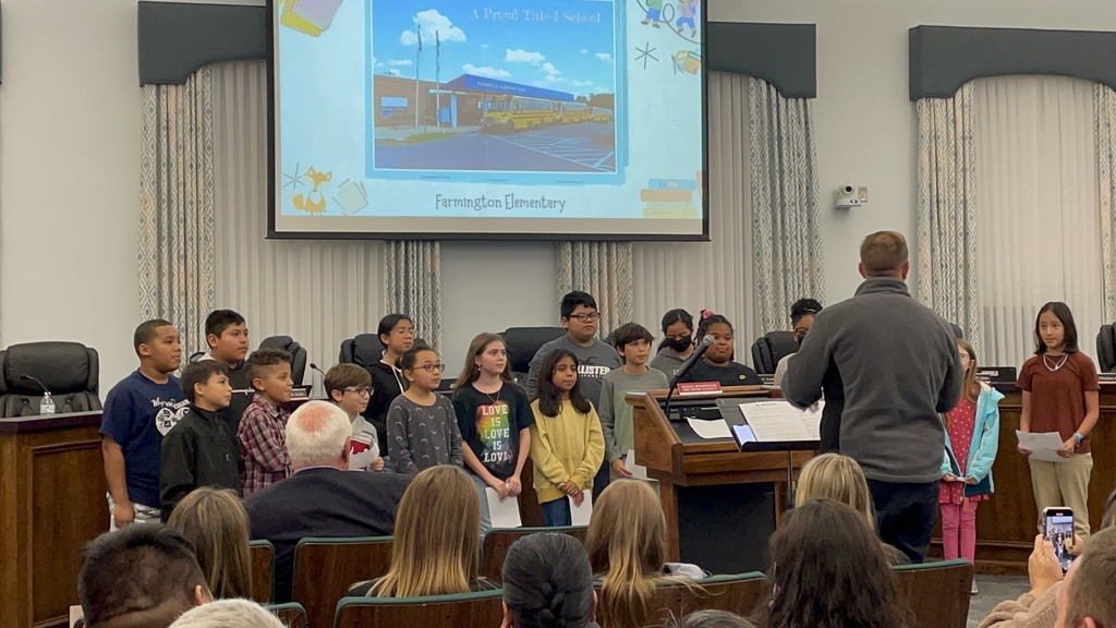 students singing at board meeting