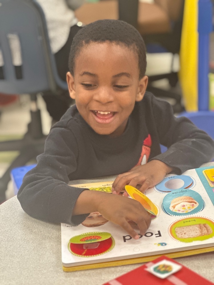 student looking at pages in a board book