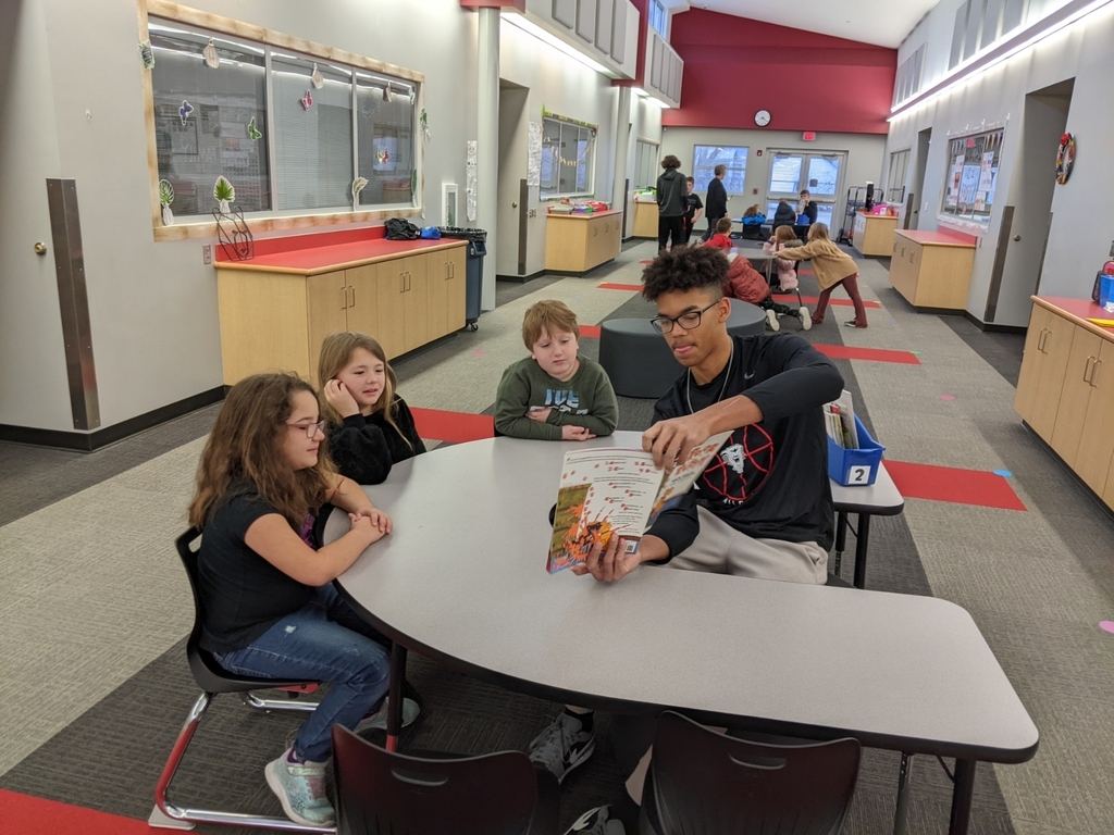 basketball player reading to second graders