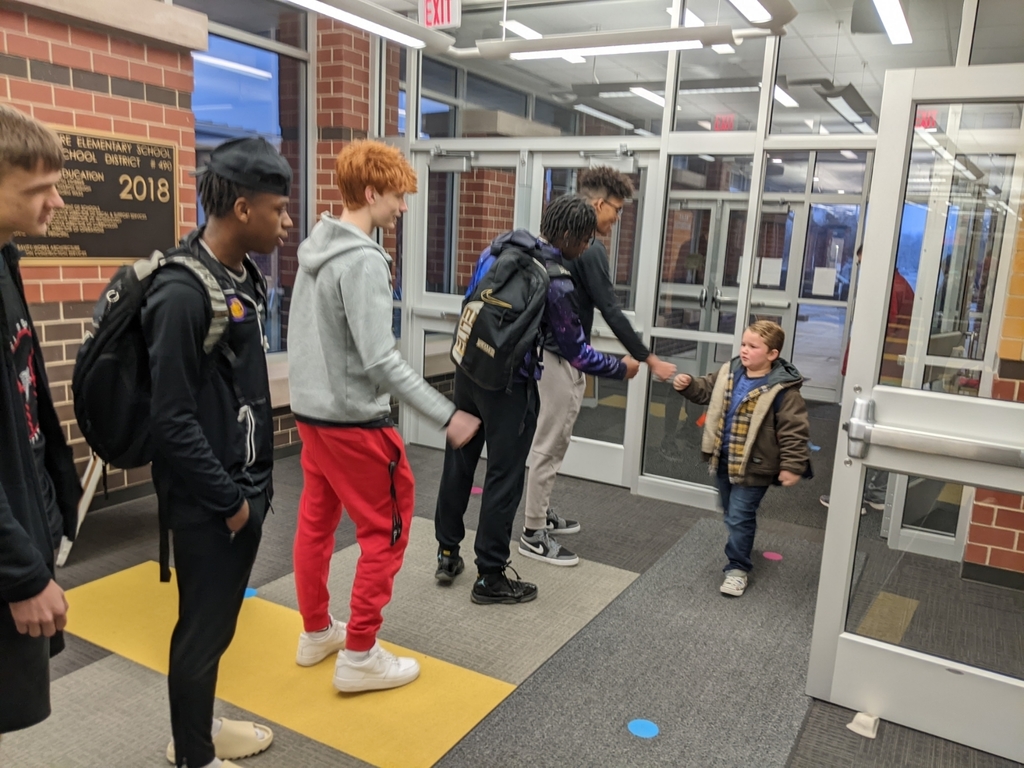 basketball players greeting students
