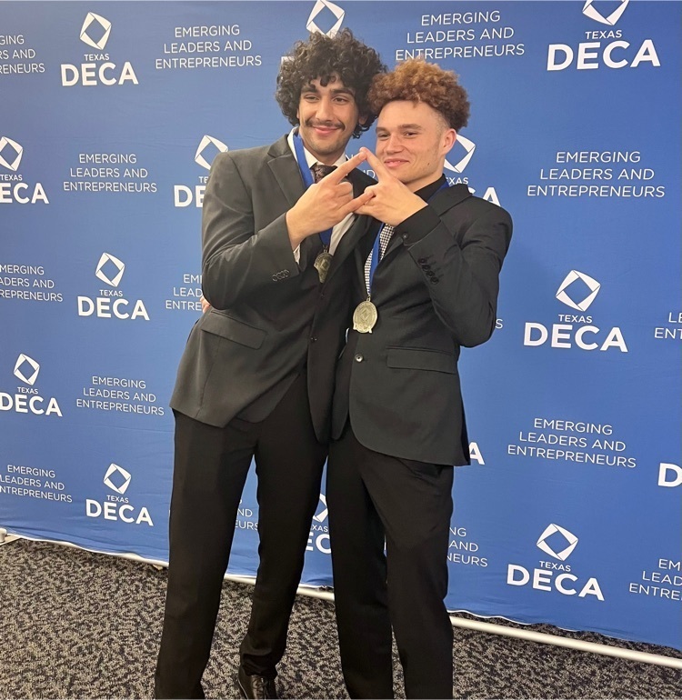 2 male students making DECA diamond with hands.