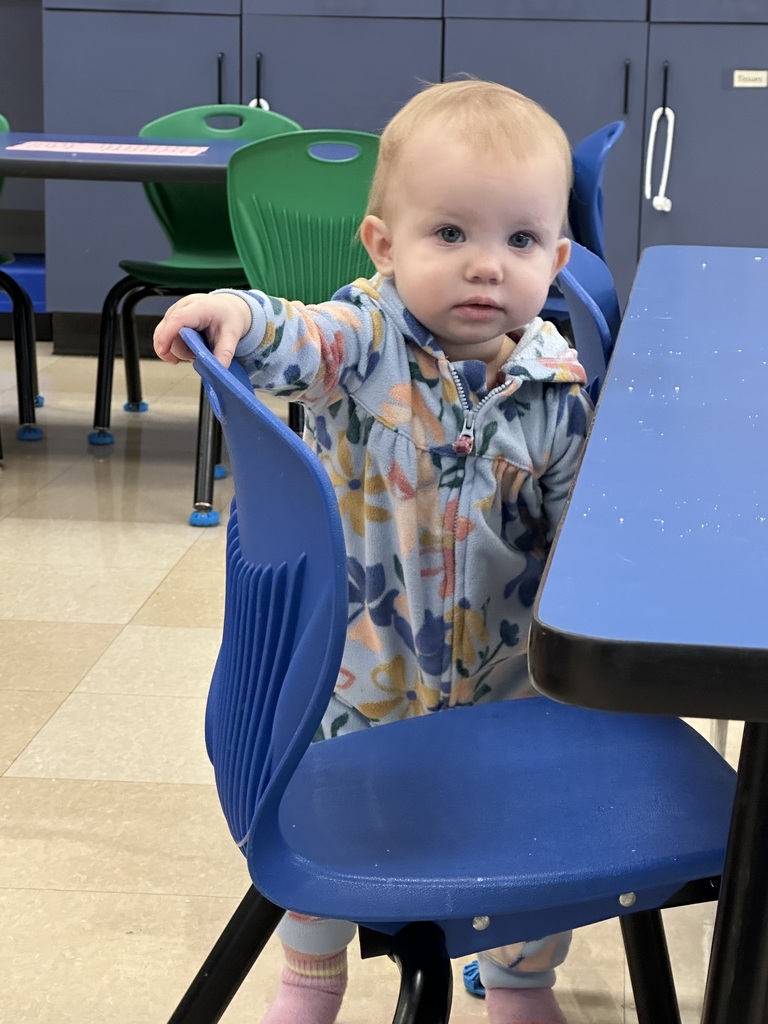 Toddler girl stands by desk