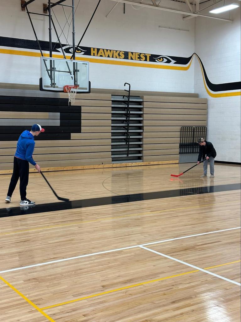 Students playing floor hockey