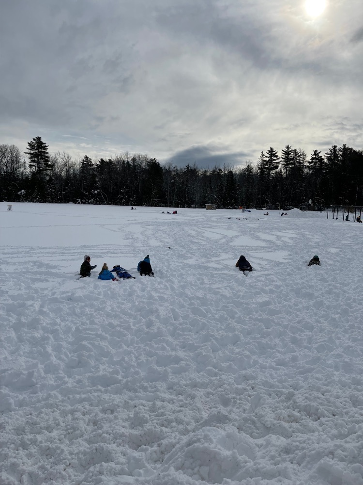 an landscape image of the sky and playground field with students playing 