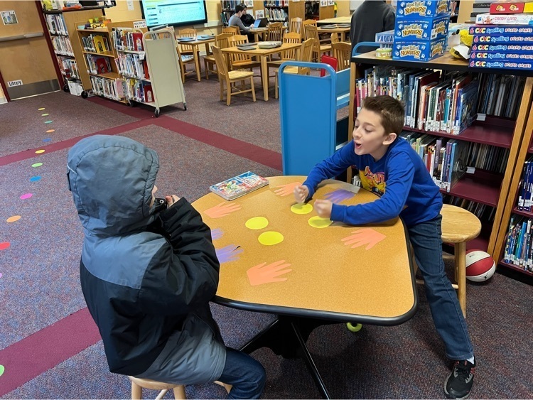 students play a game at a table in the library