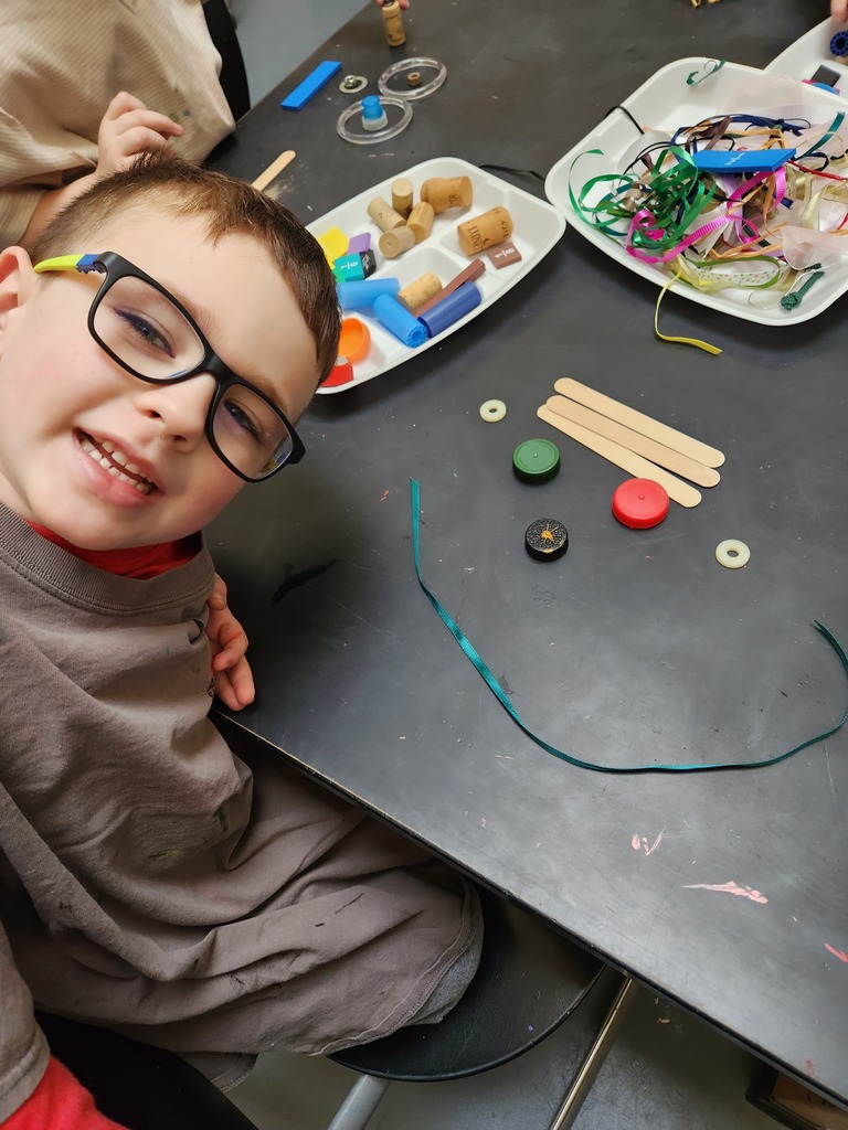 kindergarten student shows his face made of recycled materials