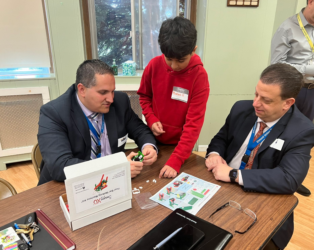 Student helping school leaders build robots
