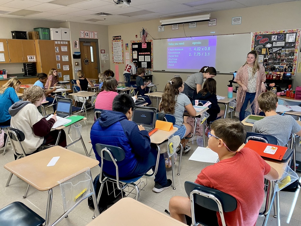 seventh grade students sit at desks in a classroom working on math