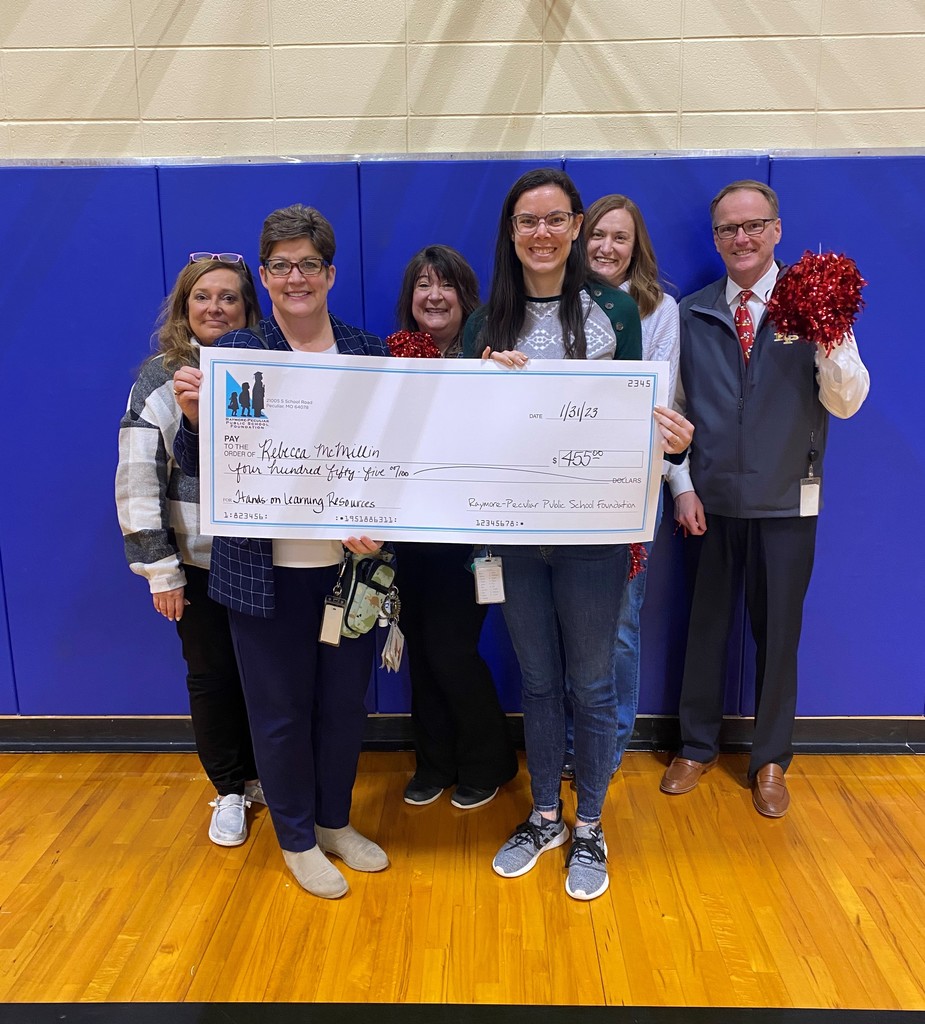 Shull Early Learning Teacher Rebecca McMillin holds a giant check