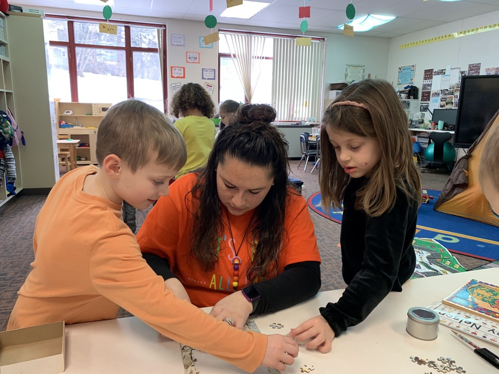 Mrs. Padua works on a puzzle with her students.