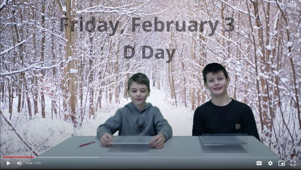 two students at news desk with snow lined path on green screen