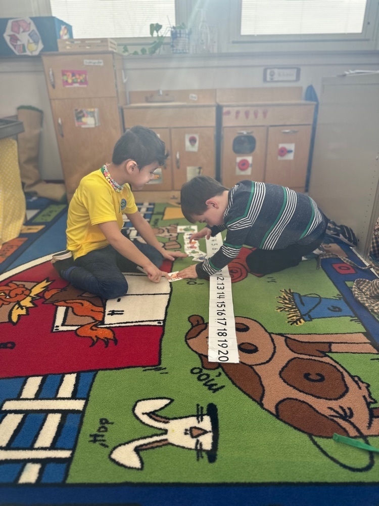 Pre-K students working teams to order numbers with the assistance of a number line