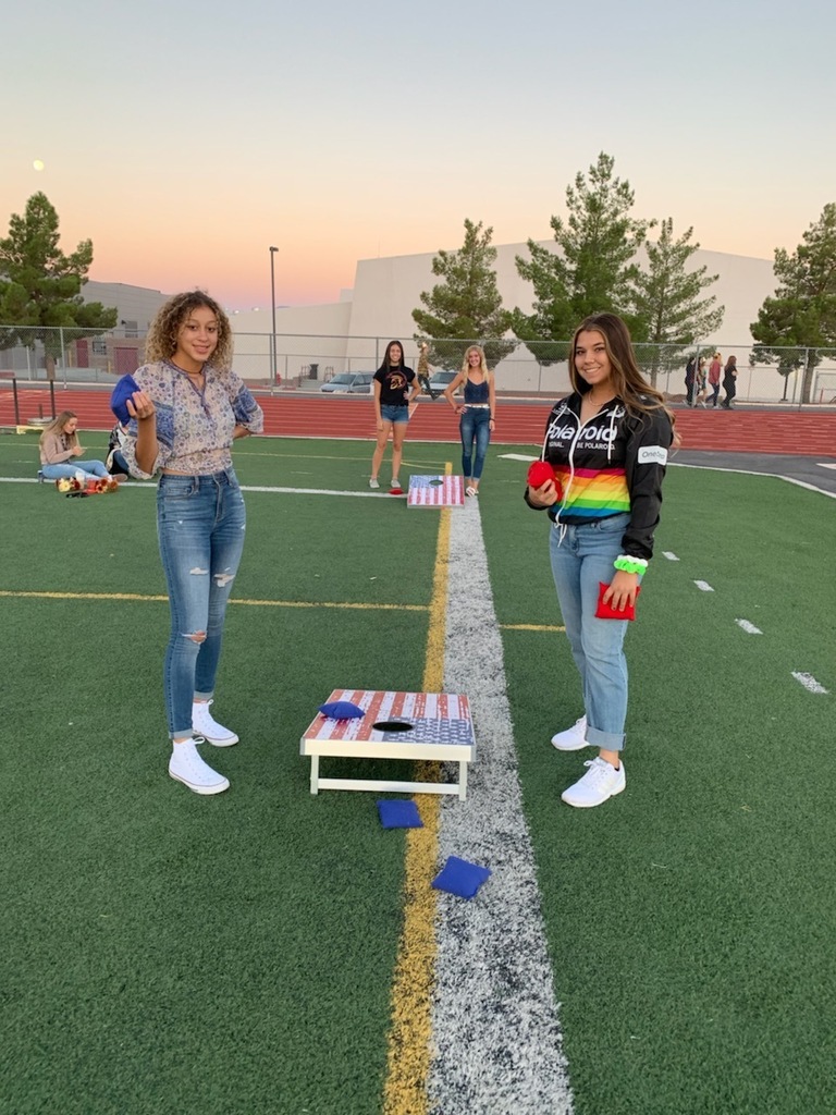 Students playing cornhole in the early morning.  