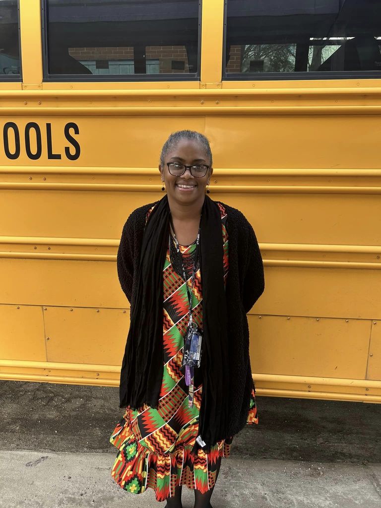 Woman smiling in front of school bus