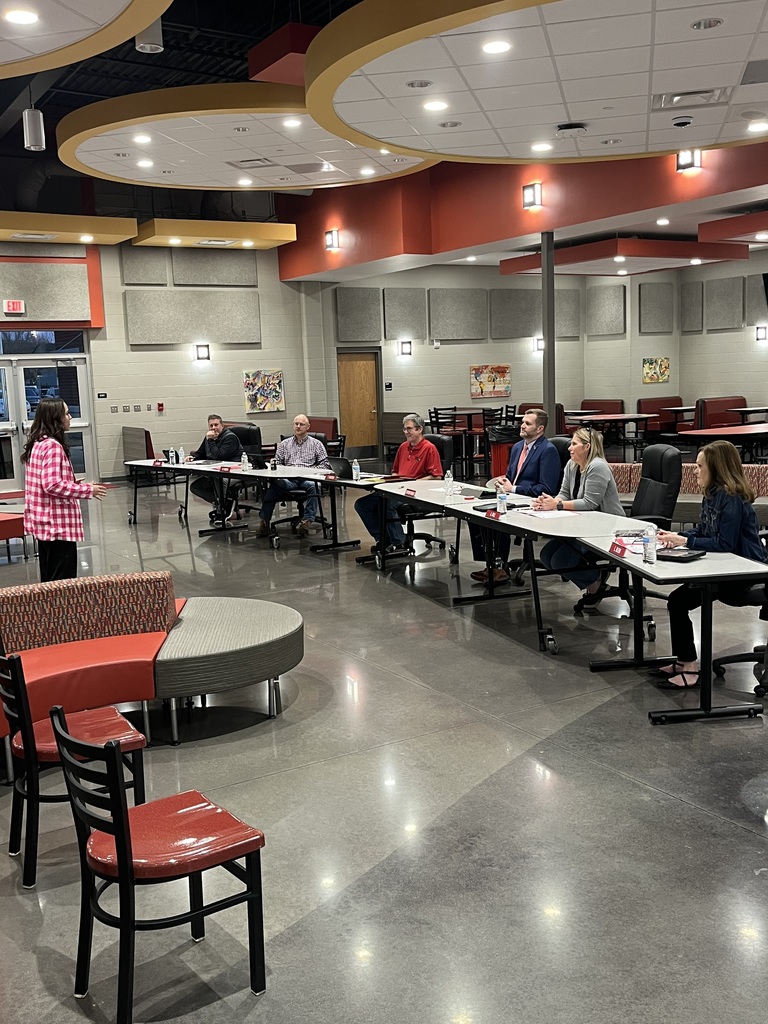 student standing in front of school board memebrs giving her speech