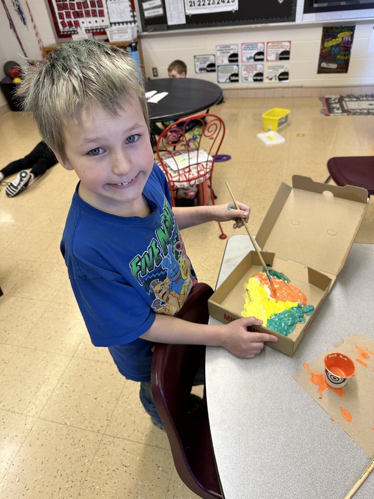 a student paints his Wisconsin landform region models made out of salt dough