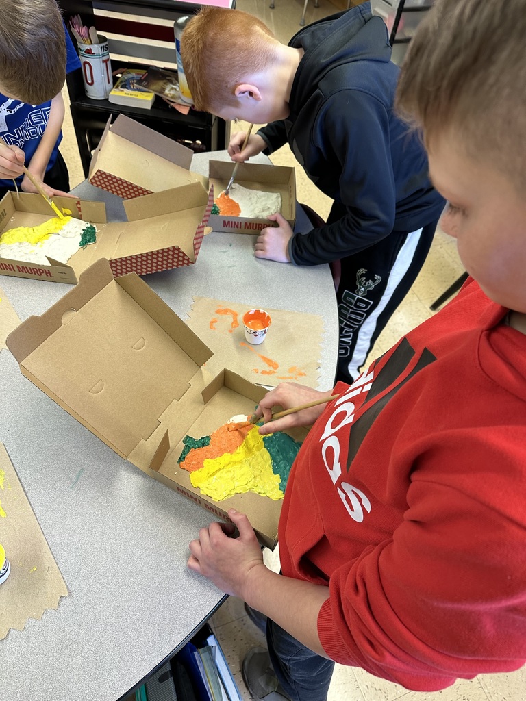 Students paint their Wisconsin landform region models made out of salt dough