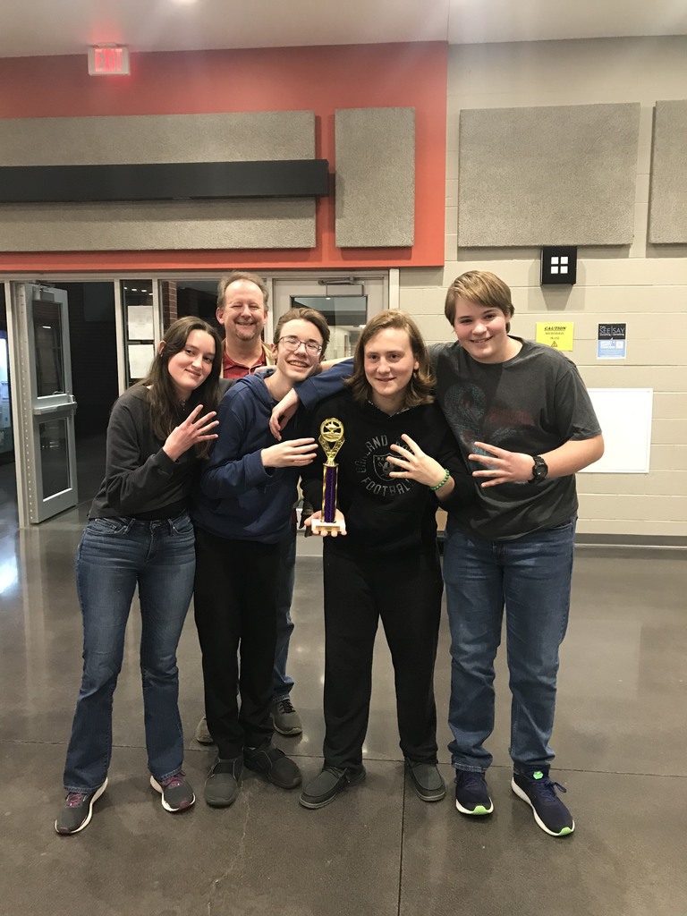 students posing with coach and trophy