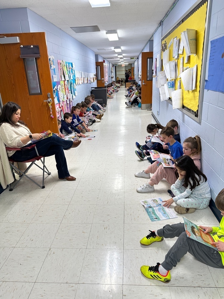 Wilson first graders sitting in the hallway, reading