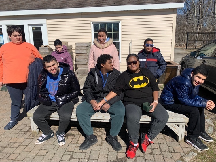 the care academy class poses for a group photo outside of the greenhouse 