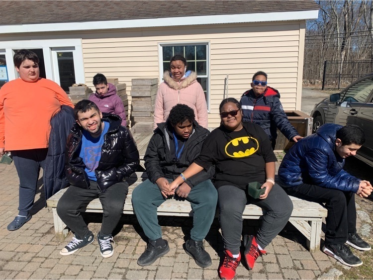 the care academy class poses for a group photo outside the greenhouse