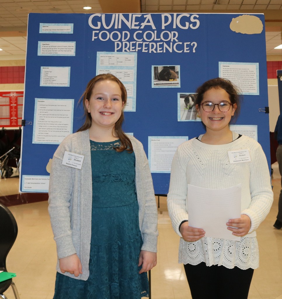 Two students pose with their science fair project. 